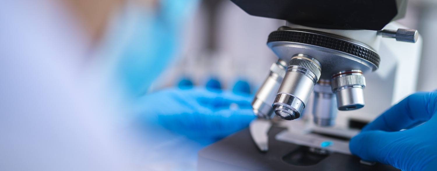 Microscope with man in gloves